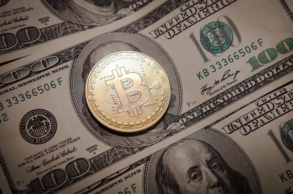 Bitcoin golden coin on top of US dollar notes